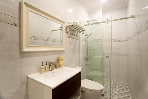 a white bathroom with a sink and a shower at BinBin Phúc Dalat Hotel in Da Lat