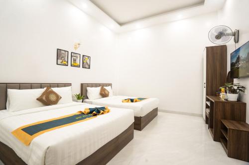 a bedroom with two beds and a television in it at BinBin Phúc Dalat Hotel in Da Lat