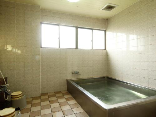 a bathroom with a tub and a toilet at Naitouya in Minamichita