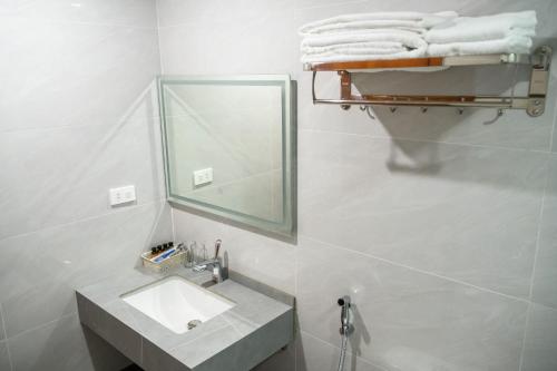 a bathroom with a sink and a mirror and towels at Hồng Ngọc Hạ Long Hotel in Ha Long