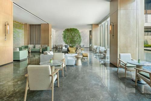a lobby with tables and chairs in a building at Element Guangzhou Baiyun in Guangzhou