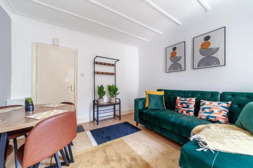 a living room with a green couch and a table at One bedroom flat in the heart of Brixton in London