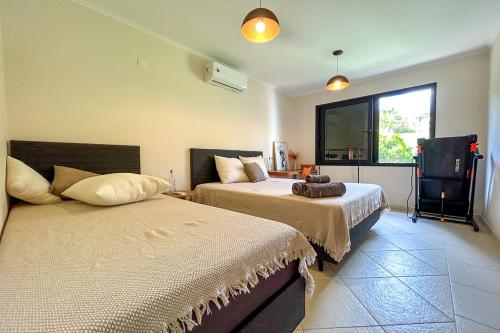 1 Schlafzimmer mit 2 Betten und einem Fenster in der Unterkunft Casa com WiFi e otima localizacao em Sao Roque SP in São Roque