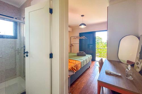 ein Schlafzimmer mit einem Bett und ein Badezimmer mit einem Spiegel in der Unterkunft Casa com WiFi e otima localizacao em Sao Roque SP in São Roque