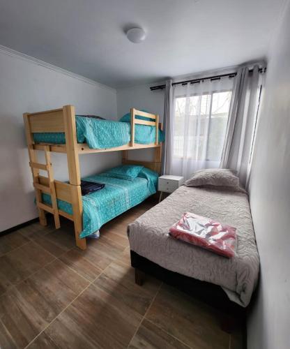 1 dormitorio con litera, 1 cama y ventana en Casa en condominio cerca de la playa El Quisco Norte, en El Quisco