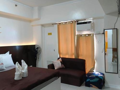 a bedroom with a bed and a chair and a window at B123 Unit 1852 Prime Residences Tagaytay Condominium - Budget Staycation - Not 5-star Hotel Accommodation in Tagaytay