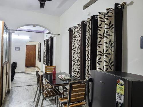 een eetkamer met een tafel en een koelkast bij KORA'S HOME STAY in Tirupati