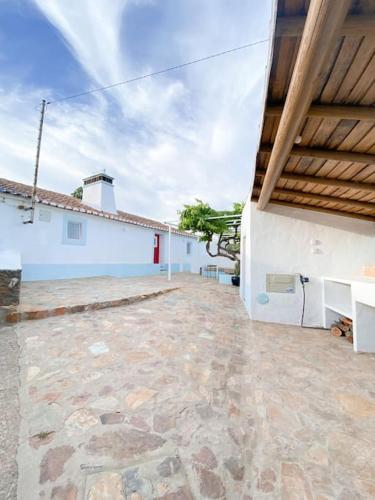 a large stone patio with a white building at Monte da Borrega - Casa de Campo in Esperança