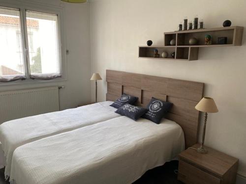 une chambre avec un grand lit blanc avec des oreillers bleus dans l'établissement Appartement T2 face à la mer, 4 couchages, Les Sables d'Olonne - Proche plage et marché - FR-1-325-9, à Les Sables-dʼOlonne