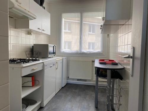 une cuisine blanche avec une cuisinière et une fenêtre dans l'établissement Appartement T2 face à la mer, 4 couchages, Les Sables d'Olonne - Proche plage et marché - FR-1-325-9, à Les Sables-dʼOlonne