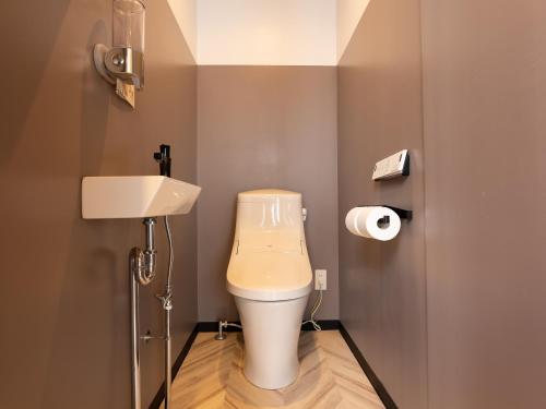 a bathroom with a toilet and a sink at Tabist MAYUDAMA CABIN in Yokohama