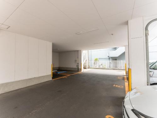 an empty parking garage with a car parked in it at Tabist MAYUDAMA CABIN in Yokohama