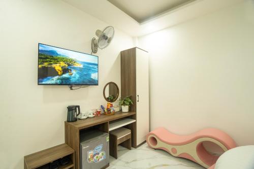 a living room with a flat screen tv on the wall at BinBin Phúc Dalat Hotel in Da Lat