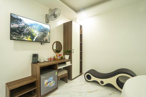 a living room with a tv on a wall at BinBin Phúc Dalat Hotel in Da Lat