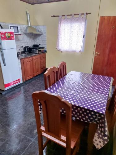 a kitchen with a table and chairs and a refrigerator at Hotel y Departamentos Arroyos in Perico