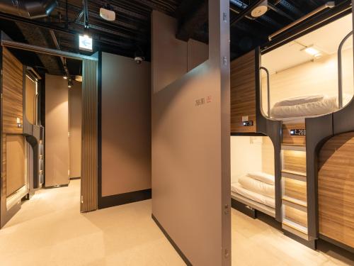 a row of bunk beds in a room at Tabist MAYUDAMA CABIN in Yokohama