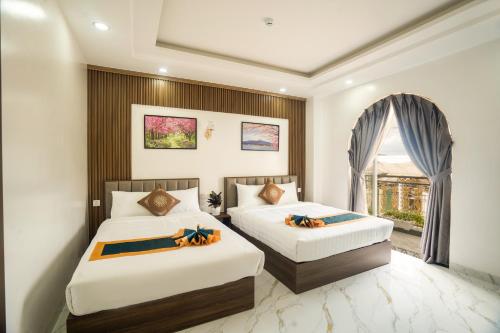 ein Hotelzimmer mit 2 Betten und einem Fenster in der Unterkunft BinBin Phúc Dalat Hotel in Da Lat