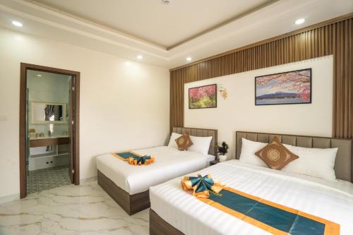 a bedroom with two beds with bows on them at BinBin Phúc Dalat Hotel in Da Lat