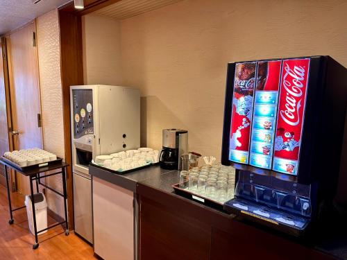 a counter with cocacola soda and a refrigerator at Atami Onsen Hotel Yume Iroha in Atami