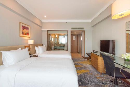 a hotel room with two beds and a television at Four Points by Sheraton Shanghai, Pudong in Shanghai