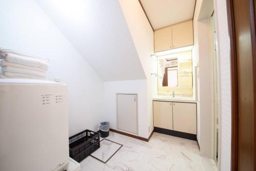 a small white bathroom with a sink and a mirror at la3 hotel annex 新宿三階建て一軒家 in Tokyo