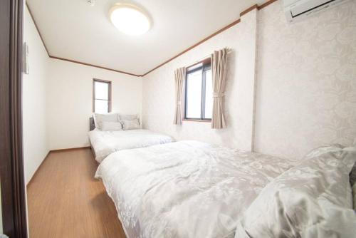 a bedroom with two beds and a window at la3 hotel annex 新宿三階建て一軒家 in Tokyo