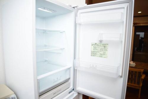 an empty refrigerator with its door open in a kitchen at la3 hotel annex 新宿三階建て一軒家 in Tokyo