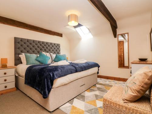 a bedroom with a large bed with a blue blanket at Riverside in St Austell