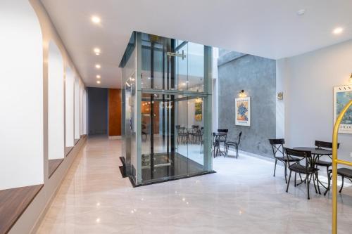 a glass elevator in a room with tables and chairs at TRUONG TIEN HOTEL in Hue