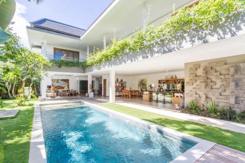 an exterior view of a house with a swimming pool at Villa Alopa Seminyak in Seminyak