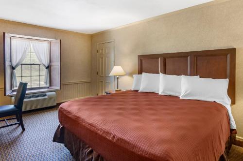 een hotelkamer met een groot bed en een raam bij The Riverstone Inn in Towanda