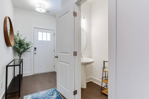 a white bathroom with a sink and a mirror at 2022 quiet relaxing and secure town house near Atlanta in Redan