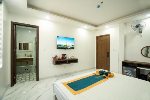 a bedroom with a bed and a tv on the wall at BinBin Phúc Dalat Hotel in Da Lat
