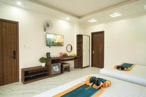 a hotel room with two beds and a desk at BinBin Phúc Dalat Hotel in Da Lat