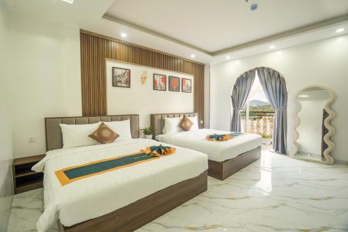 a hotel room with two beds and a window at BinBin Phúc Dalat Hotel in Da Lat