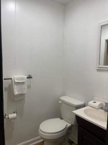 a white bathroom with a toilet and a sink at Pennswoods Inn in Manheim