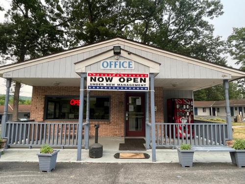a store with a sign that reads office now open at Pennswoods Inn in Manheim