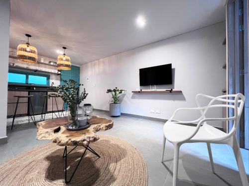 ein Wohnzimmer mit einem Tisch und Stühlen sowie einem TV in der Unterkunft Parallelo Loft Salento P1 in Salento
