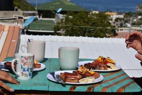 ein Tisch mit zwei Tellern Frühstücksprodukt drauf in der Unterkunft Casa MITA Taganga in Taganga