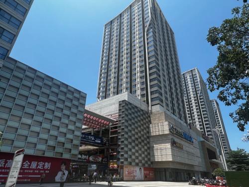 dos edificios altos en una ciudad con gente delante de ellos en Livetour Hotel Luogang Wanda Plaza Guangzhou, en Guangzhou