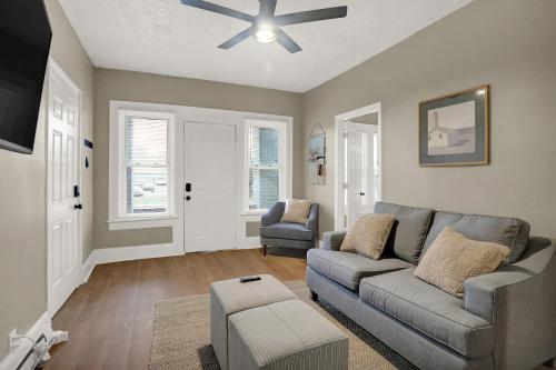 a living room with a couch and a ceiling fan at The Village Downtown West in Indianapolis