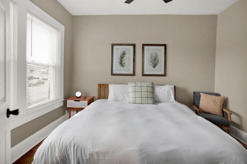 a bedroom with a large white bed and a window at The Village Downtown West in Indianapolis