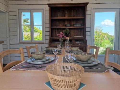 une salle à manger avec une table, des assiettes et des verres dans l'établissement Holiday Home in Locquirec near Sandy Beaches, à Locquirec