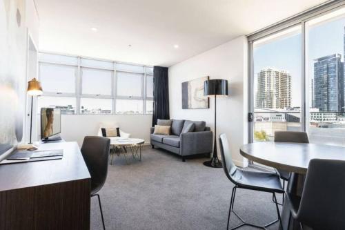 a living room with a couch and a table at Chatswood CBD 2BR l Balcony l Parking l Office in Sydney