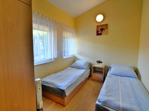 a bedroom with two beds and a window at Single-story holiday home close to the beach in Rosnowo