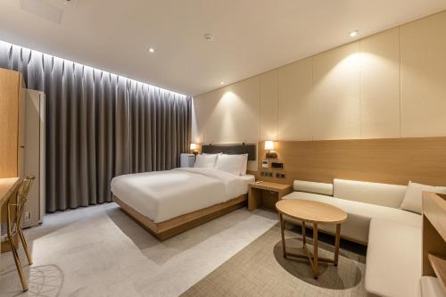 a hotel room with a bed and a couch at Masan Daisy Hotel in Changwon