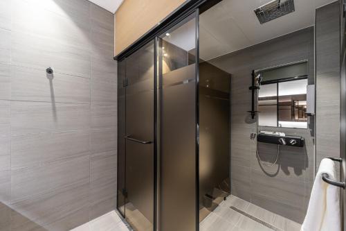 a bathroom with a shower with a glass door at Masan Daisy Hotel in Changwon