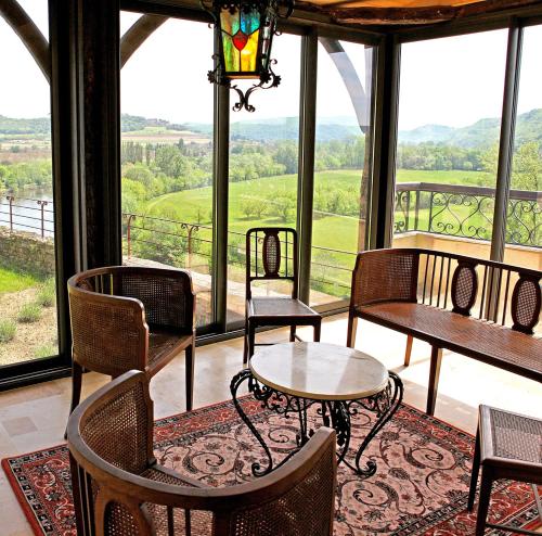 a screened in porch with chairs and tables and windows at Sarrasins Bed and Breakfast in Beynac-et-Cazenac