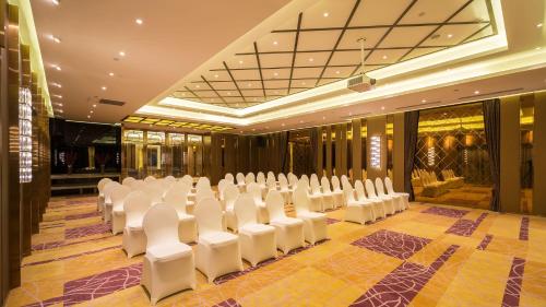 a banquet hall with white chairs and tables in it at Marco Polo Parkside, Beijing in Beijing