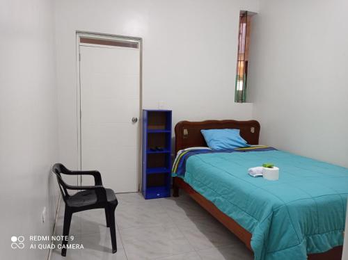 um quarto com uma cama e uma cadeira preta em Angello em Lima